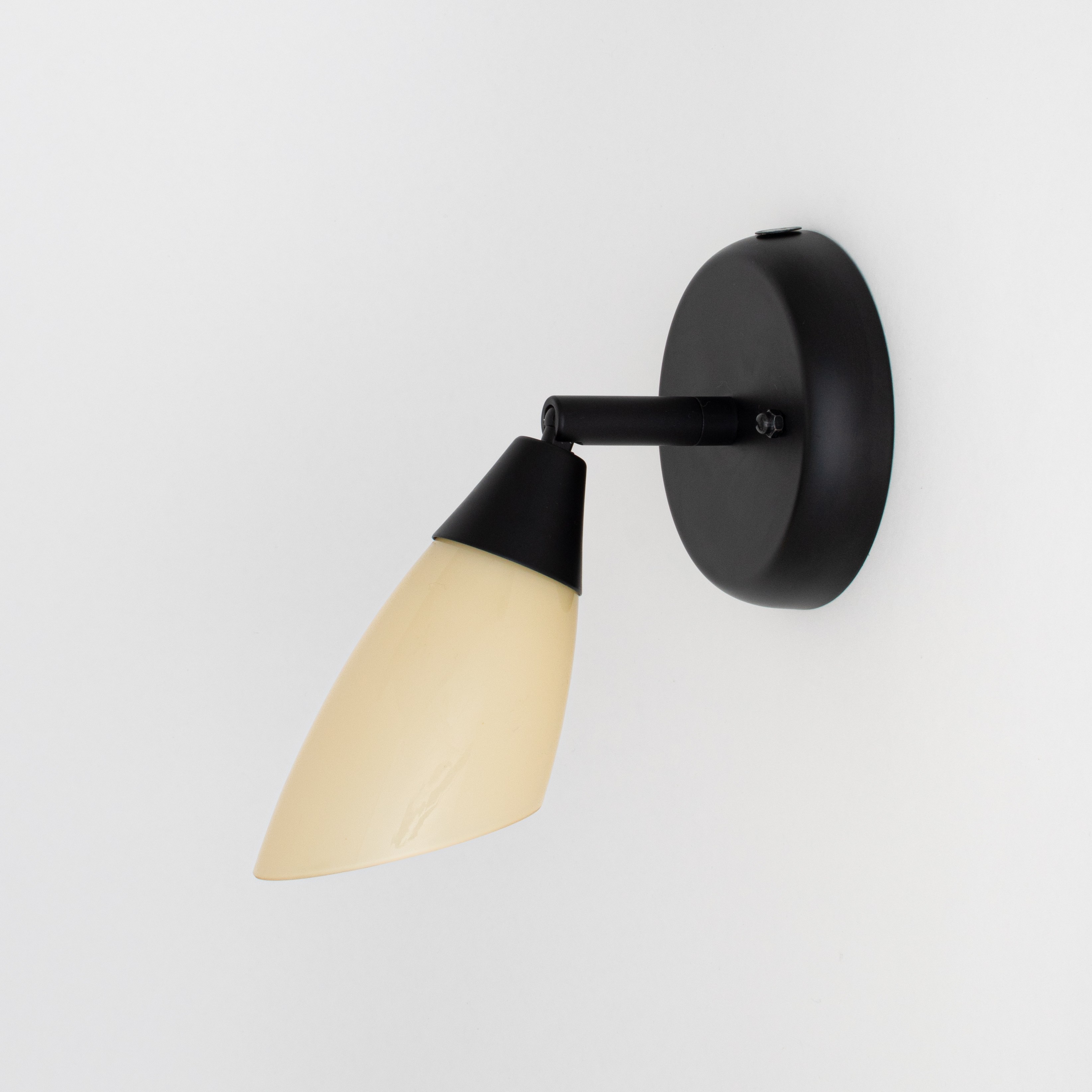 Black wall spotlight with hinge and soft yellow glass shade